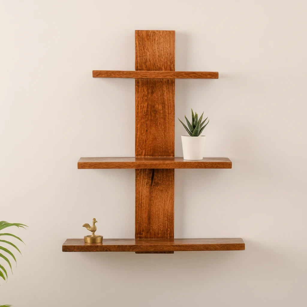 WOOD CURLS 3-tier wall-mounted mango wood shelf with natural brown finish, displaying a small plant and brass figurine.