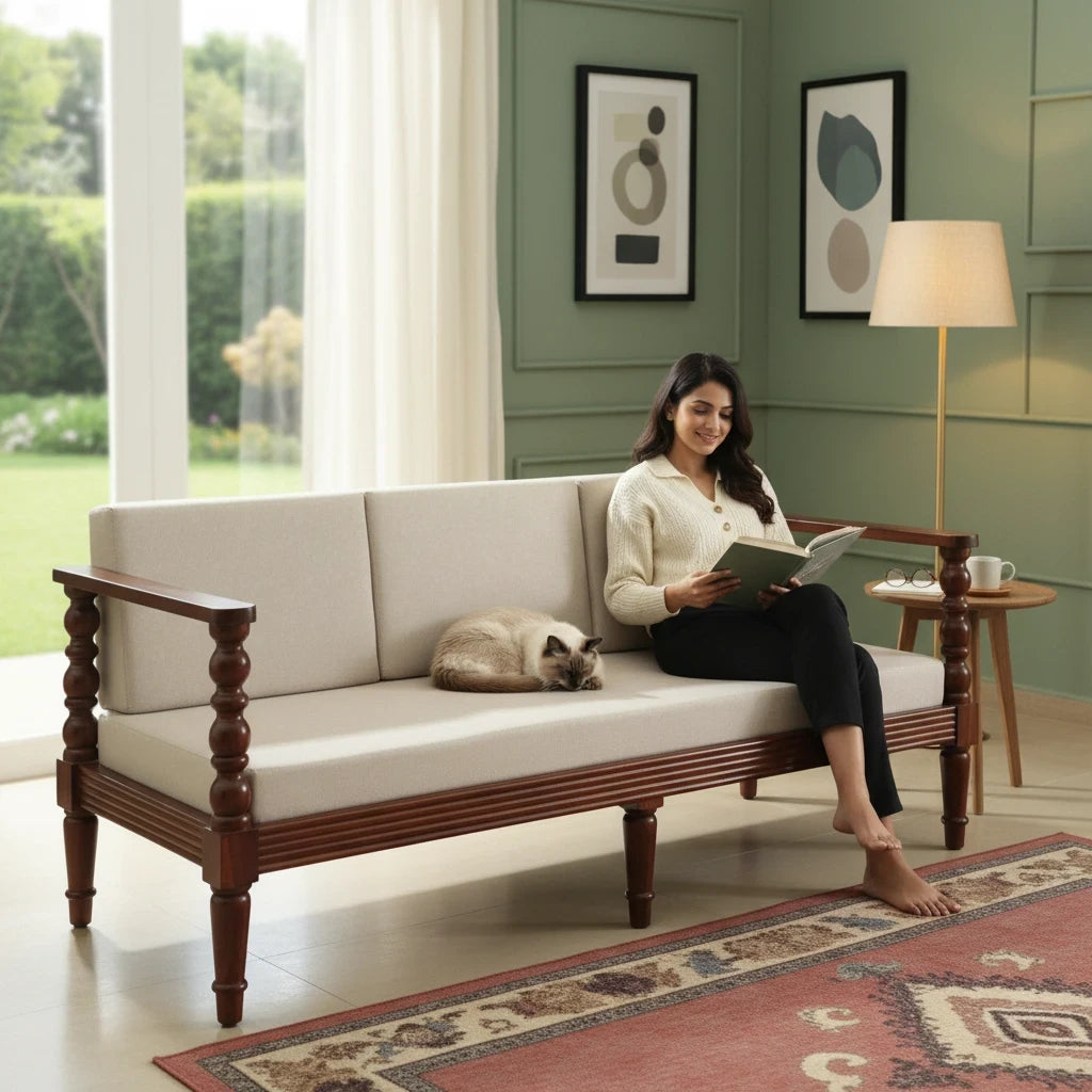 WOOD CURLS three seater sofa in beige upholstery with solid Sheesham wood frame and carved arms, woman reading on it