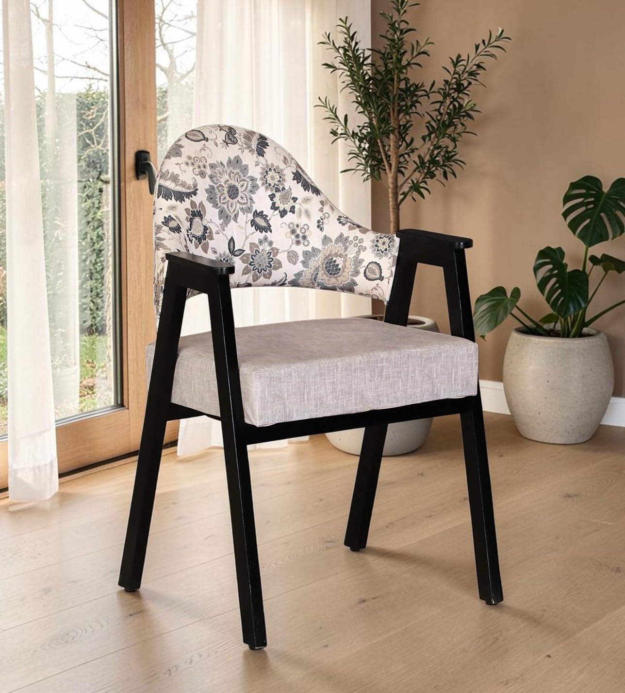 Wood Curls Florence Sheesham wood arm chair with floral upholstered backrest and black wooden frame in a modern living room