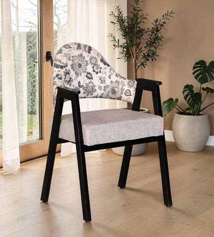 Wood Curls Florence Sheesham wood arm chair with floral upholstered backrest and black wooden frame in a modern living room