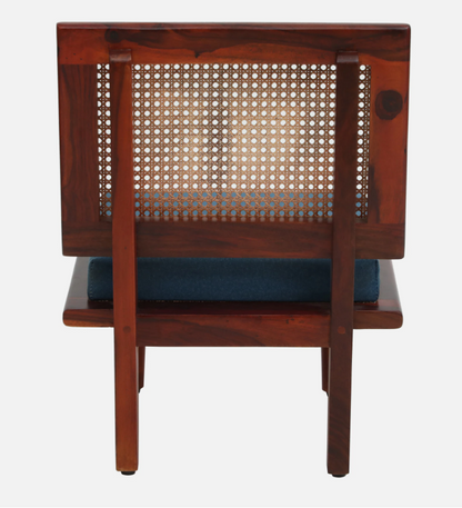 Wooden chair with wicker backrest and blue cushion on a white background