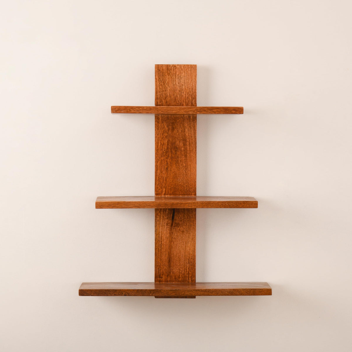 WOOD CURLS 3-tier wall-mounted shelf made from natural brown mango wood with a minimalist vertical design.