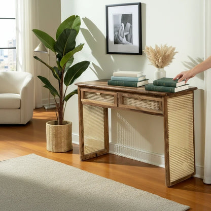 WOOD CURLS Aster console desk in solid acacia wood with woven cane drawer fronts and side panels in a bright room.