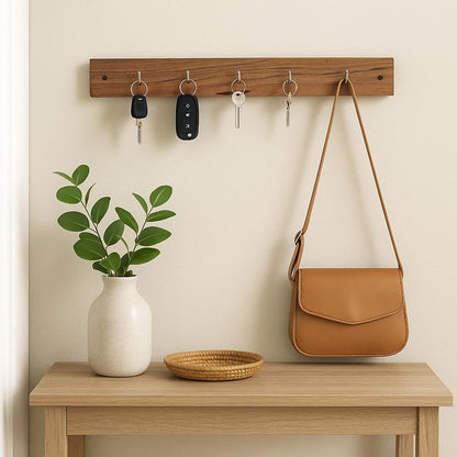 WOOD CURLS wall-mount key holder made of natural acacia wood with 5 hooks, mounted above a wooden console table.