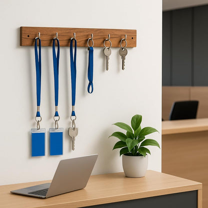 WOOD CURLS wall-mount key holder made of natural acacia wood with 5 metal hooks holding keys and blue lanyards.