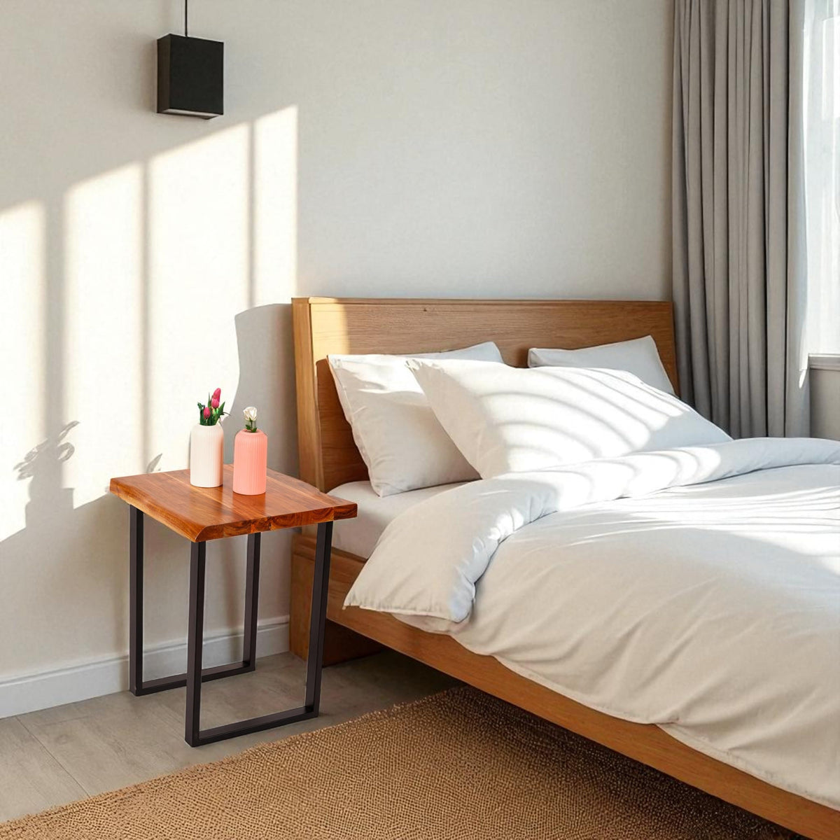 WOOD CURLS square acacia wood coffee table with natural grain finish and black metal legs beside a wooden bed frame.