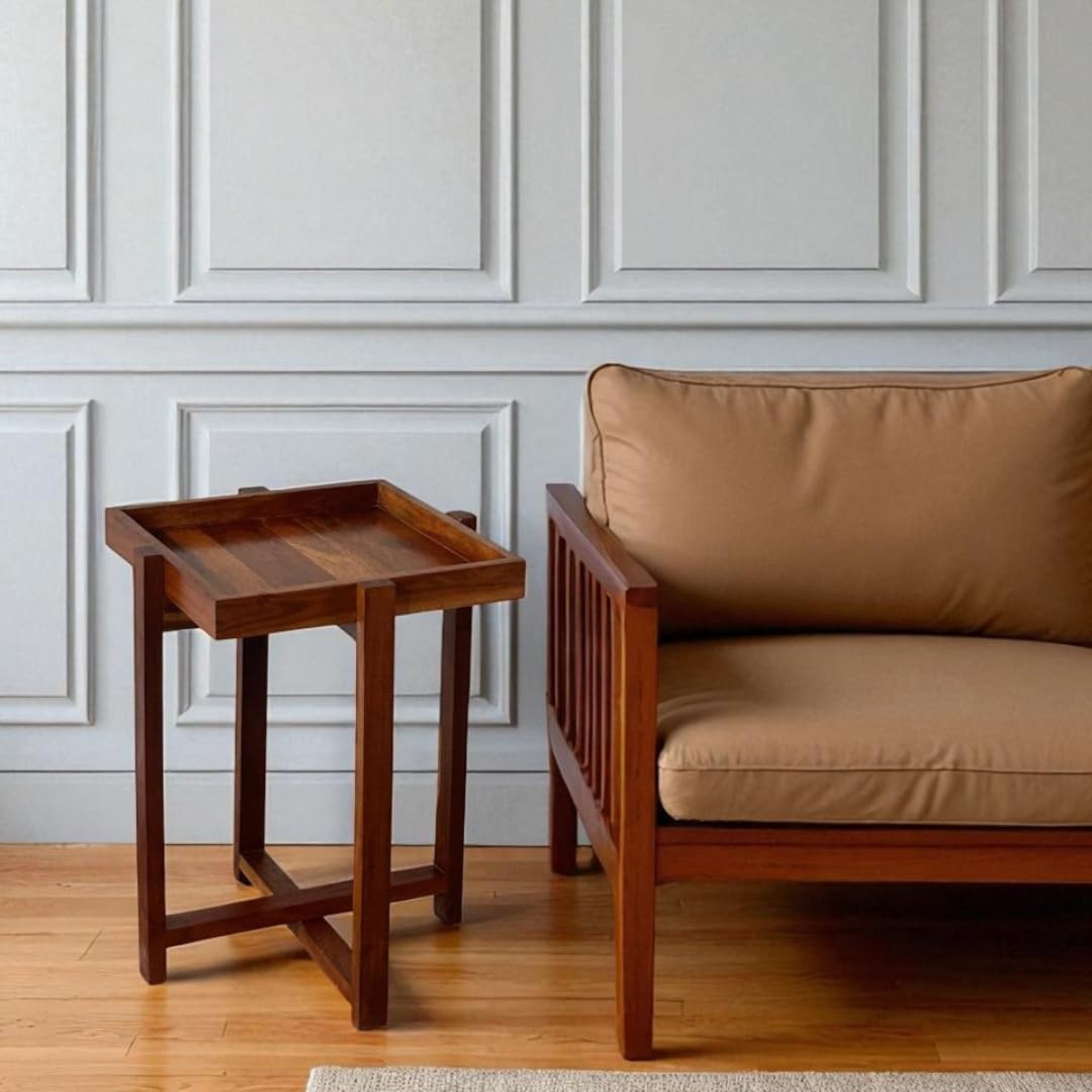 WOOD CURLS Enigma square center table made of acacia wood with a tray-style top next to a tan upholstered chair.