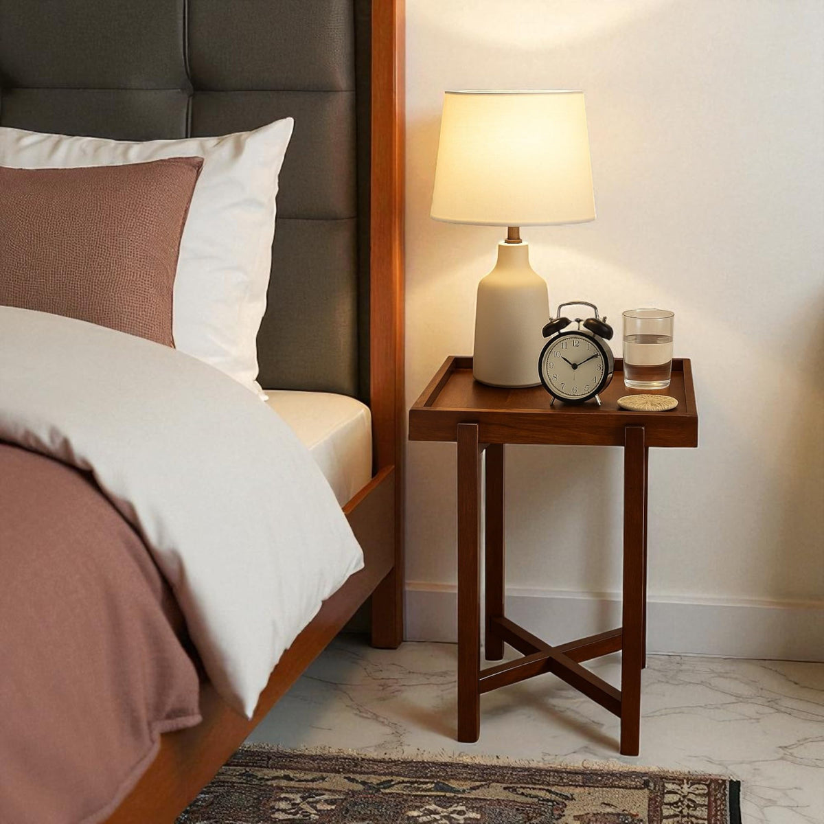 WOOD CURLS Enigma square acacia wood side table with a lamp, alarm clock, and glass of water in a bedroom setting.