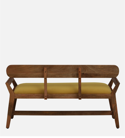 WOOD CURLS Alderra mango wood bench with a mustard velvet seat, backrest, and tapered legs in a mid-century style.