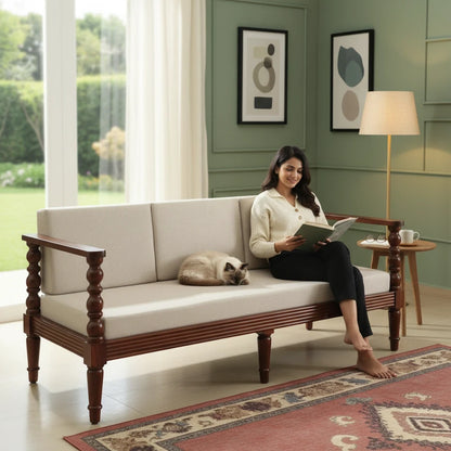 WOOD CURLS three seater sofa in beige upholstery with solid Sheesham wood frame and carved arms, woman reading on it