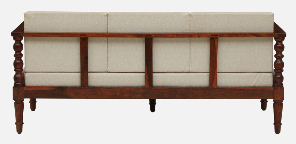WOOD CURLS Auburn three seater sofa featuring a solid Sheesham wood frame with carved details and beige upholstery.