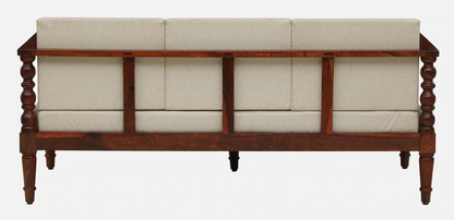 WOOD CURLS Auburn three seater sofa featuring a solid Sheesham wood frame with carved details and beige upholstery.