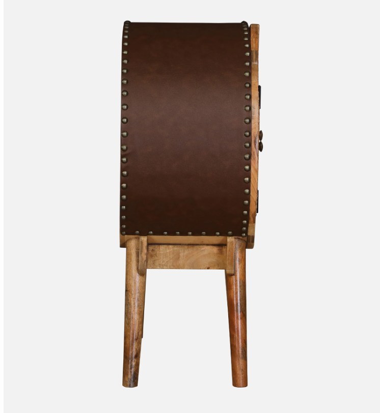 WOOD CURLS Ayra round mango wood cabinet side view featuring a brown leatherette back panel with antique metal studs.