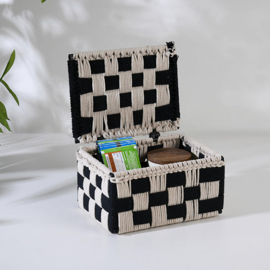 WOOD CURLS handwoven cotton rope storage box with a black and beige checkered pattern and an open hinged lid.