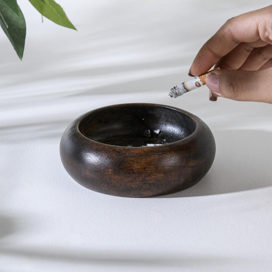 WOOD CURLS handcrafted dark brown wooden ashtray with a deep bowl design being used on a white surface