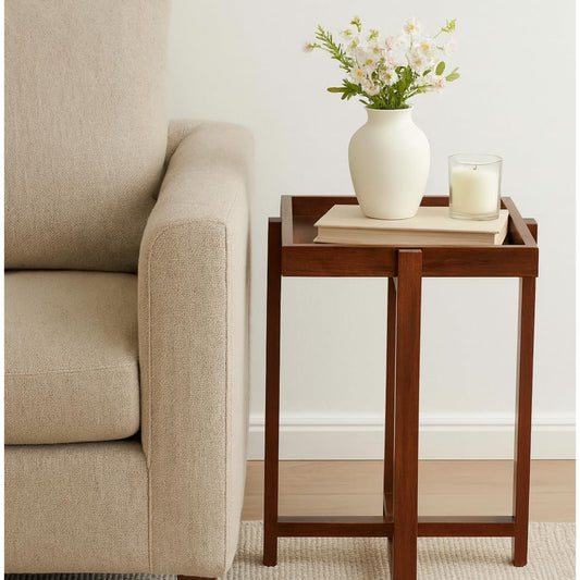 WOOD CURLS Enigma square acacia wood center table with a reversible top, styled next to a beige sofa with decor.