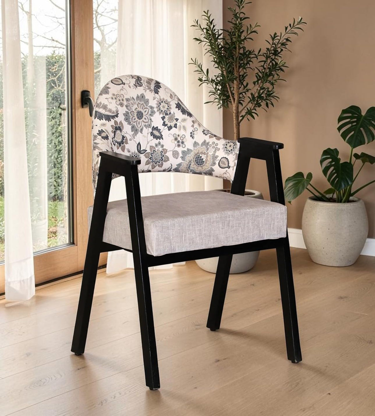 WOOD CURLS Florence arm chair with black Sheesham wood frame, floral print backrest, and grey cushioned seat.