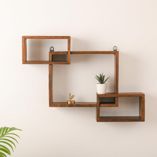 WOOD CURLS geometric intersecting wall shelf made of solid brown mango wood mounted on a plain white wall.