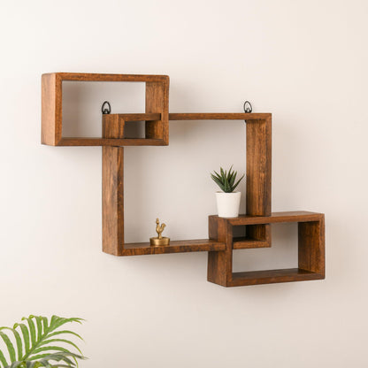 WOOD CURLS intersecting geometric wall shelf made of solid brown mango wood displaying a small plant and figurine.
