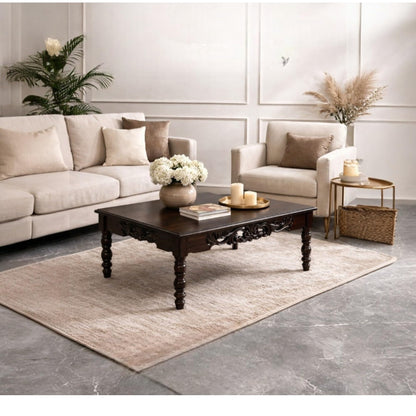 WOOD CURLS handcrafted dark wood center table with intricate carvings and turned legs in a bright living room