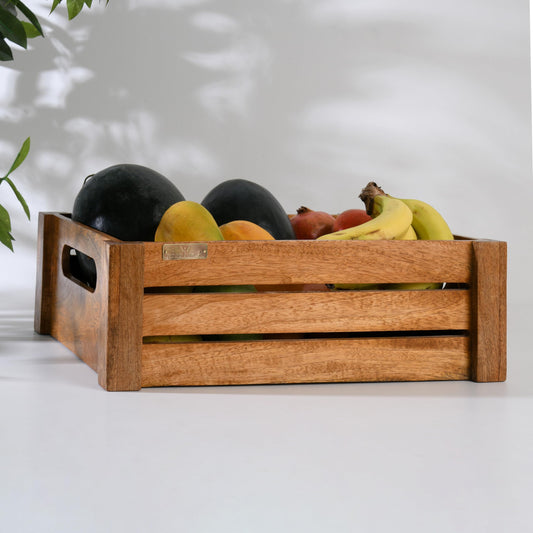 WOOD CURLS handcrafted mango wood crate filled with fresh fruits like bananas and melons on a white surface