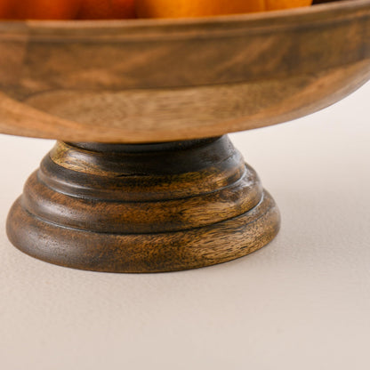 WOOD CURLS handcrafted mango wood pedestal bowl with a natural finish and visible wood grain on a neutral background.