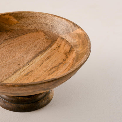 WOOD CURLS handcrafted mango wood pedestal bowl with a natural finish and visible wood grain patterns.