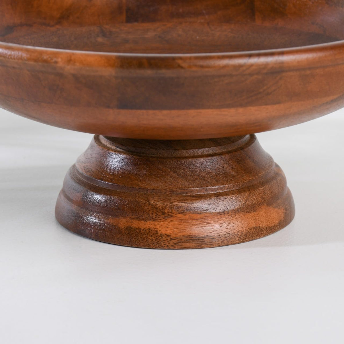 WOOD CURLS handcrafted mango wood pedestal fruit bowl with a smooth finish and raised base for table centerpieces.