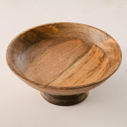 WOOD CURLS handcrafted mango wood pedestal bowl with a natural finish and visible wood grain patterns.
