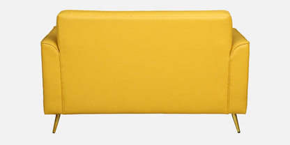 WOOD CURLS Aurelia mustard leatherette two-seater sofa back view with elegant golden metal legs