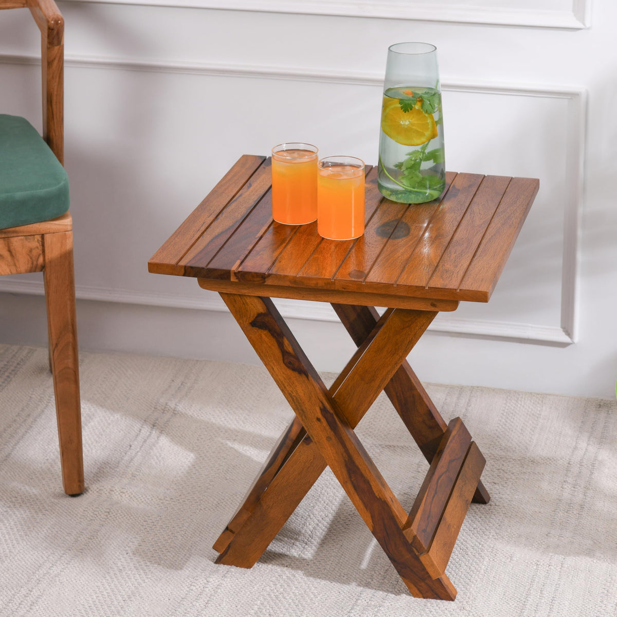 WOOD CURLS Nova square coffee table in natural Sheesham wood with a folding X-frame base and drinks on top