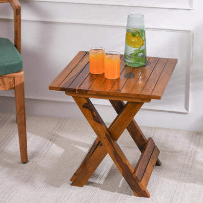 WOOD CURLS Nova square coffee table in natural Sheesham wood with a folding X-frame base and drinks on top