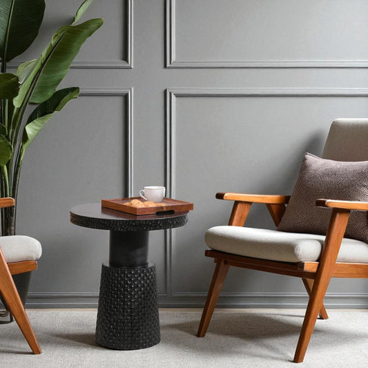 WOOD CURLS Nyx round black mango wood coffee table with textured base in a modern living room setting