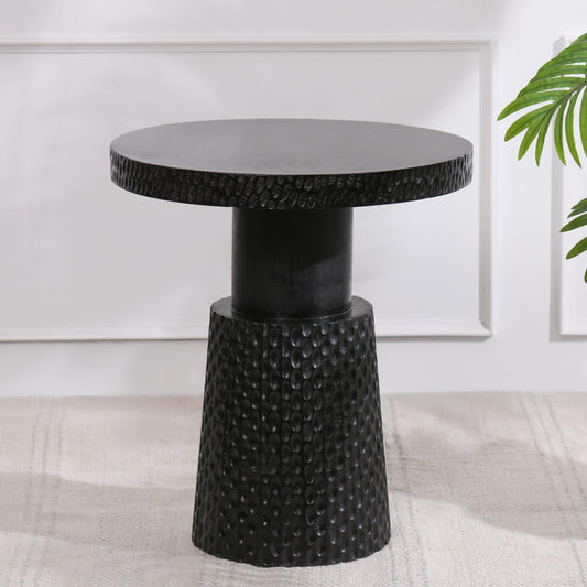 WOOD CURLS Nyx round coffee table in black mango wood with a textured pedestal base for modern living spaces.