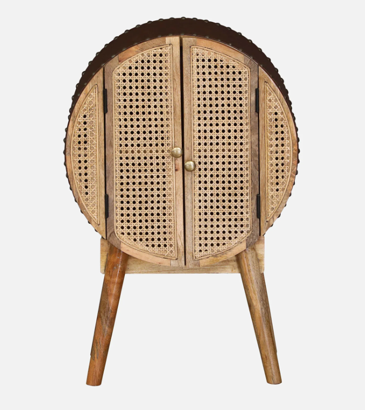 WOOD CURLS Ayra round mango wood cabinet with woven cane doors, gold knobs, and tapered legs in a mid-century style.