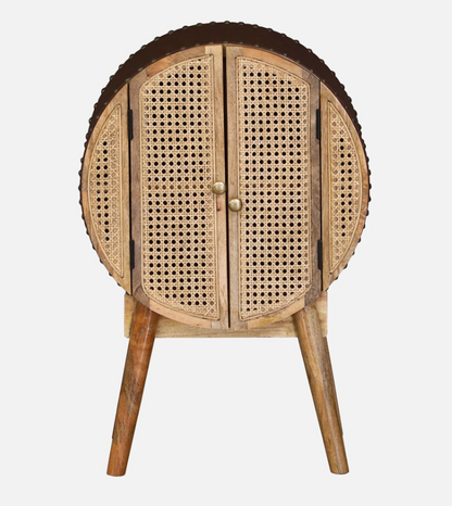 WOOD CURLS Ayra round mango wood cabinet with woven cane doors, gold knobs, and tapered legs in a mid-century style.