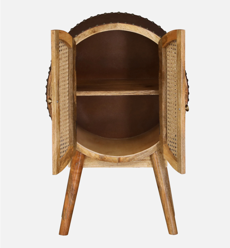 WOOD CURLS round mango wood cabinet with open cane doors, interior shelf, and tapered legs in a mid-century style.