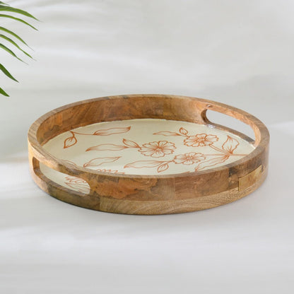 WOOD CURLS round mango wood serving tray with a cream base and hand-painted copper floral design and side handles.