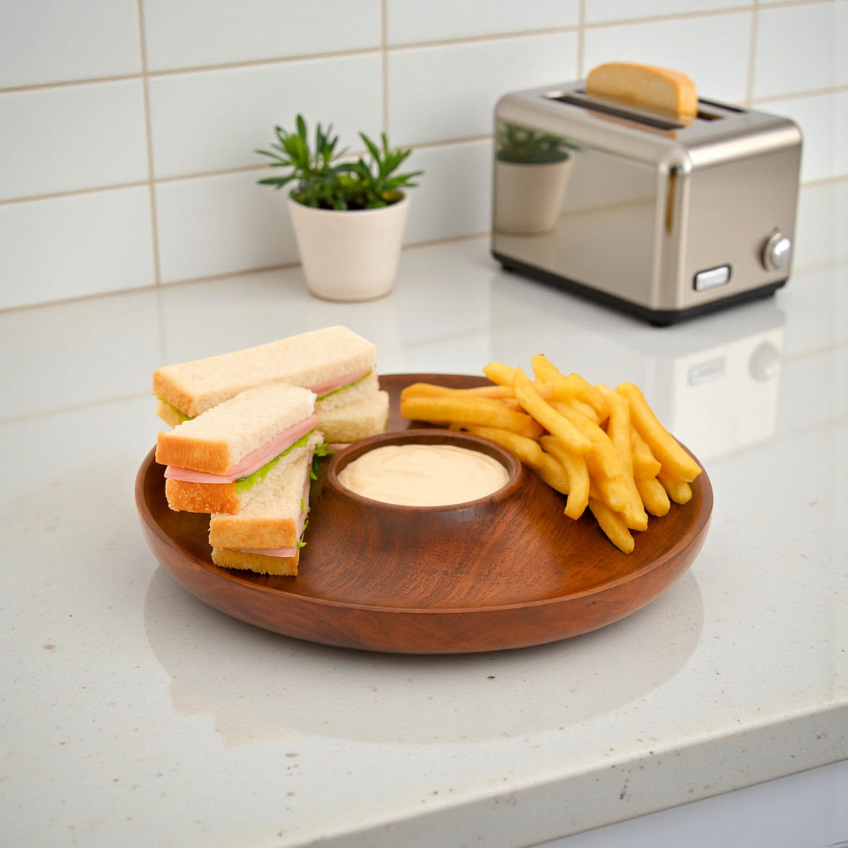 WOOD CURLS handcrafted round mango wood chip and dip platter holding sandwiches, fries, and sauce on a kitchen counter
