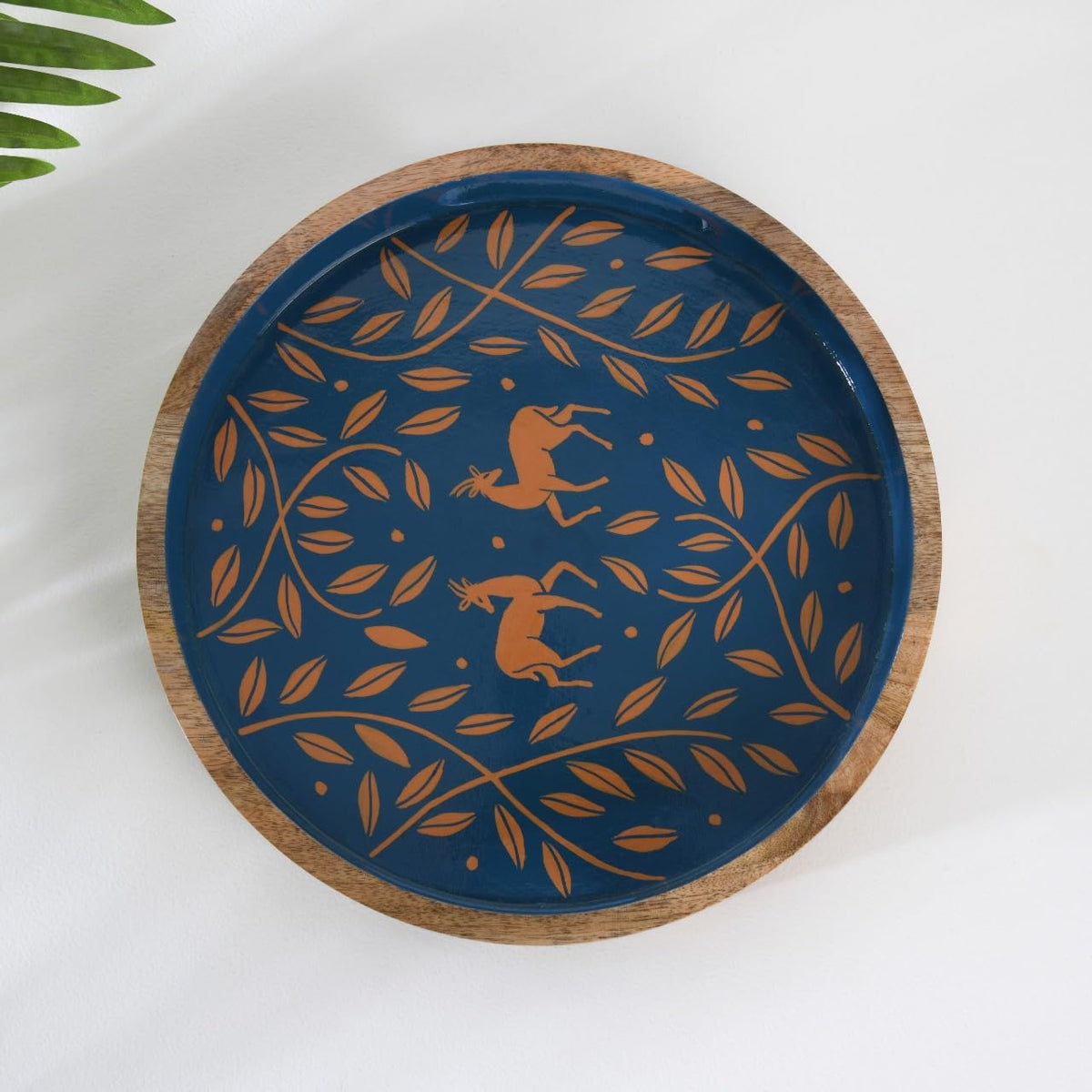 WOOD CURLS round mango wood serving tray with navy blue base and handpainted copper antelope and leaf motif