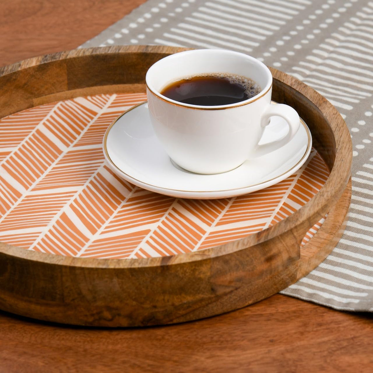 WOOD CURLS round wooden serving tray with a peach geometric enamel base holding a white coffee cup and saucer