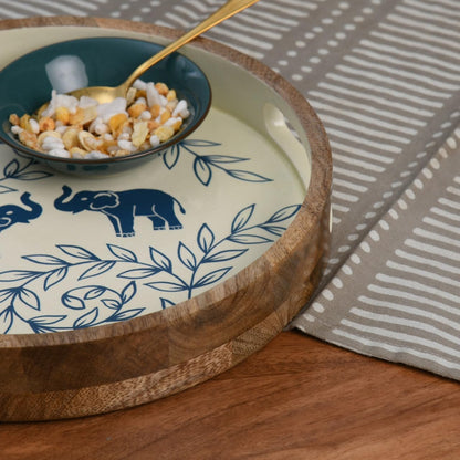 WOOD CURLS round wooden serving tray with hand-painted blue elephant and leaf motifs on a cream background