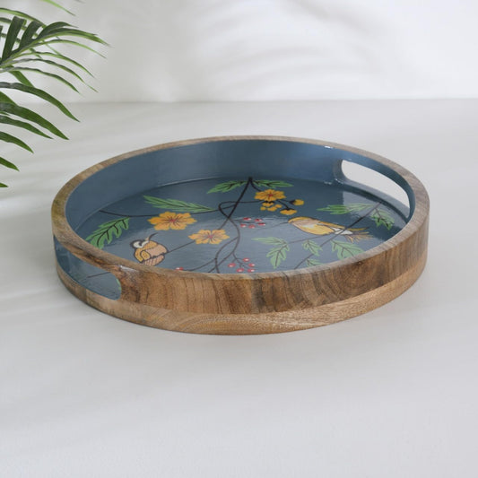 WOOD CURLS round mango wood serving tray featuring a hand-painted blue interior with yellow birds and floral motifs.
