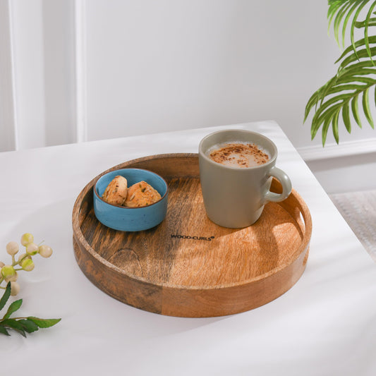 WOOD CURLS round wooden serving tray with a natural brown finish holding a coffee mug and a small bowl of cookies.