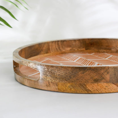 WOOD CURLS round wooden serving tray with a peach geometric herringbone enamel base and natural wood grain finish.