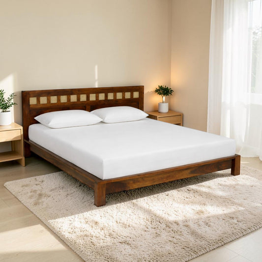 WOOD CURLS king size Aranya bed in solid Sheesham wood with a decorative cane headboard in a bright bedroom setting.