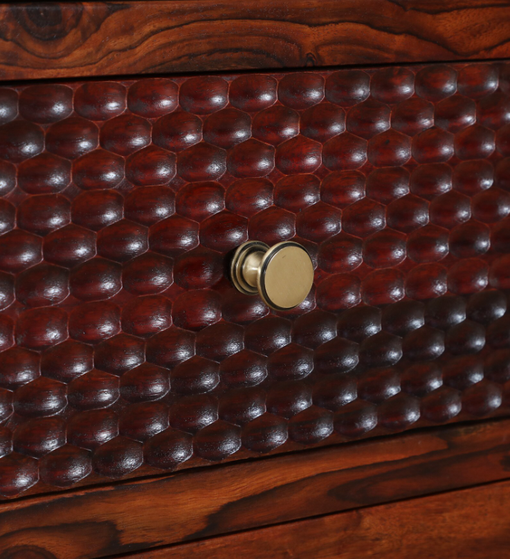 Close-up of a wooden drawer with a textured surface and gold handle.
