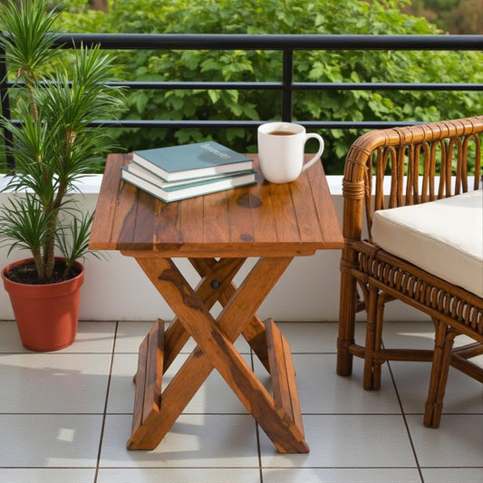 WOOD CURLS Nova square Sheesham wood coffee table with natural finish, styled on a balcony with books and a mug.
