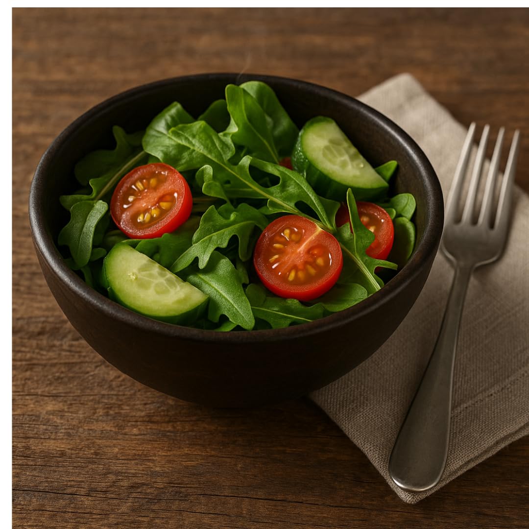 WOOD CURLS small dark brown mango wood serving bowl filled with a fresh salad of arugula, cucumber, and cherry tomatoes.