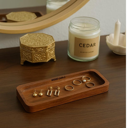 WOOD CURLS minimalist solid acacia wood desk organizer tray holding gold earrings and rings on a wooden surface
